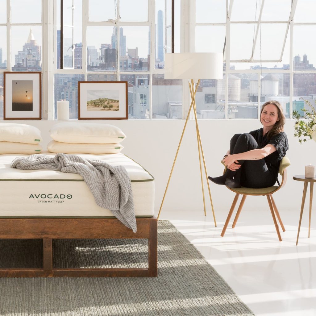 Avocado Green Mattress in a loft bedroom with a woman seated nearby