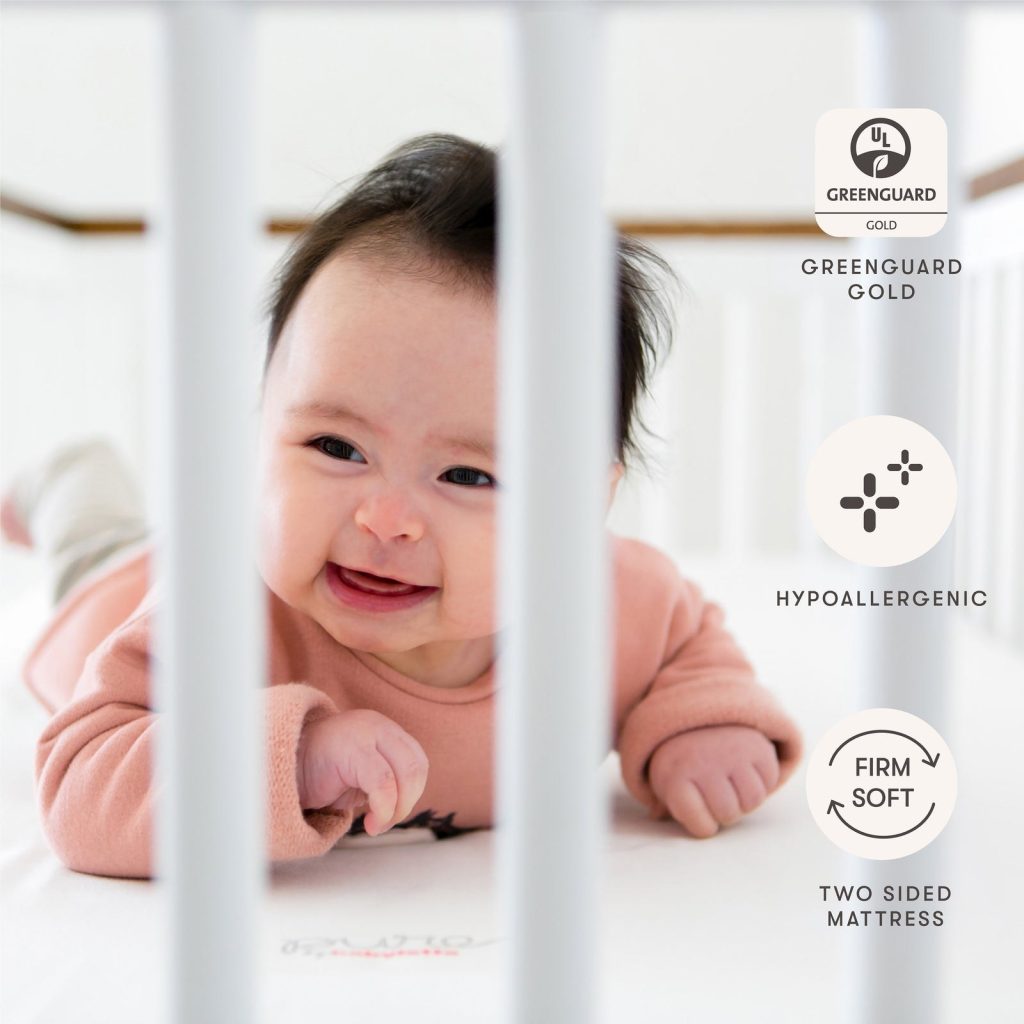 Smiling baby lying on the Babyletto Pure Core mattress behind crib slats