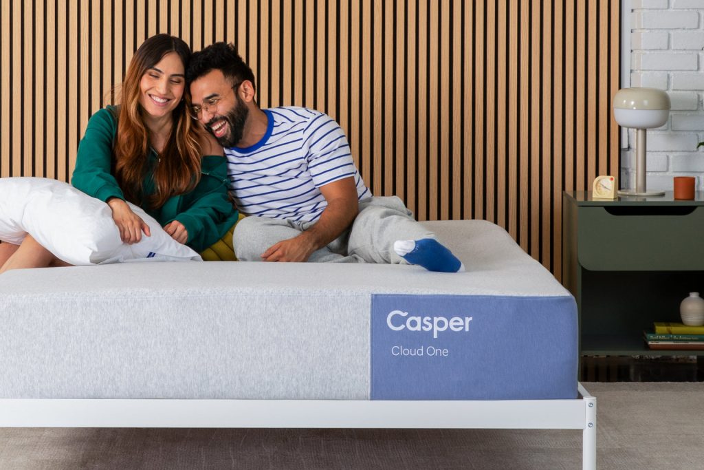 Couple sitting and laughing on the Casper Cloud One mattress