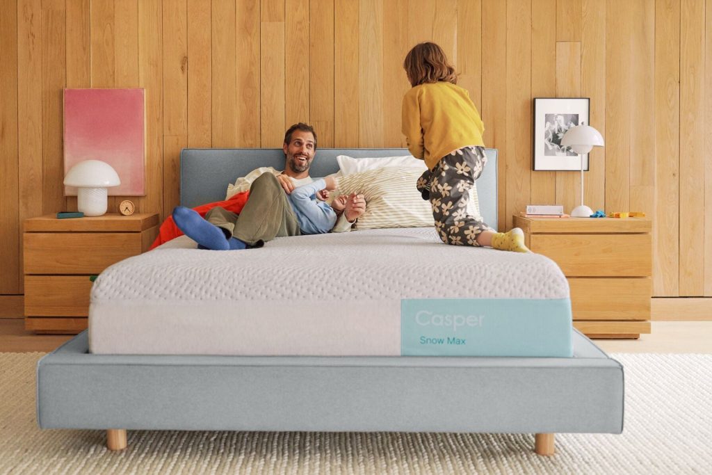 Couple relaxing on the Casper Snow Max in a wood paneled bedroom