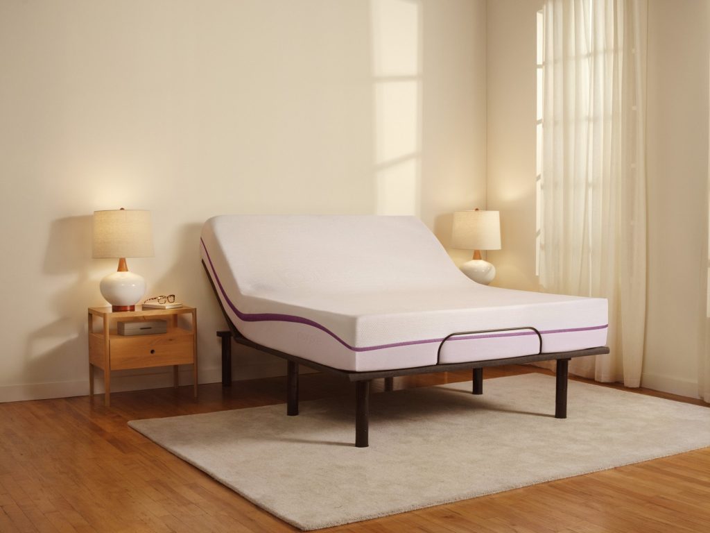 The Purple Mattress on an adjustable base in a bedroom with a rug
