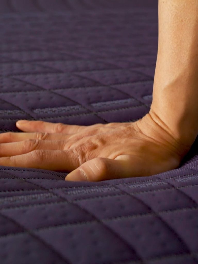 Hand pressing into the quilted DreamLayer top of the Purple Rejuvenate