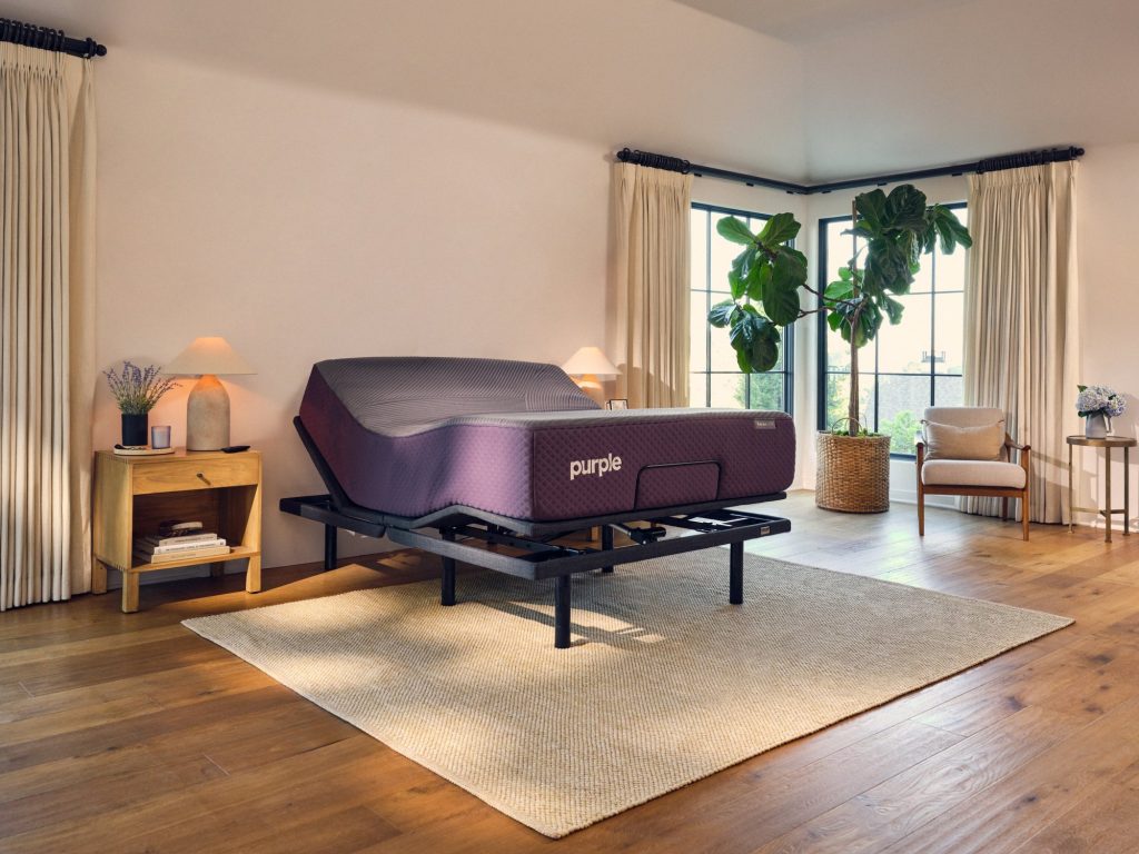 Purple RestorePremier Hybrid raised on an adjustable base in a bright bedroom