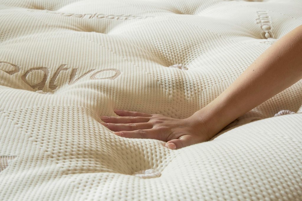 Hand pressing into the organic cotton cover of the Saatva Latex Hybrid