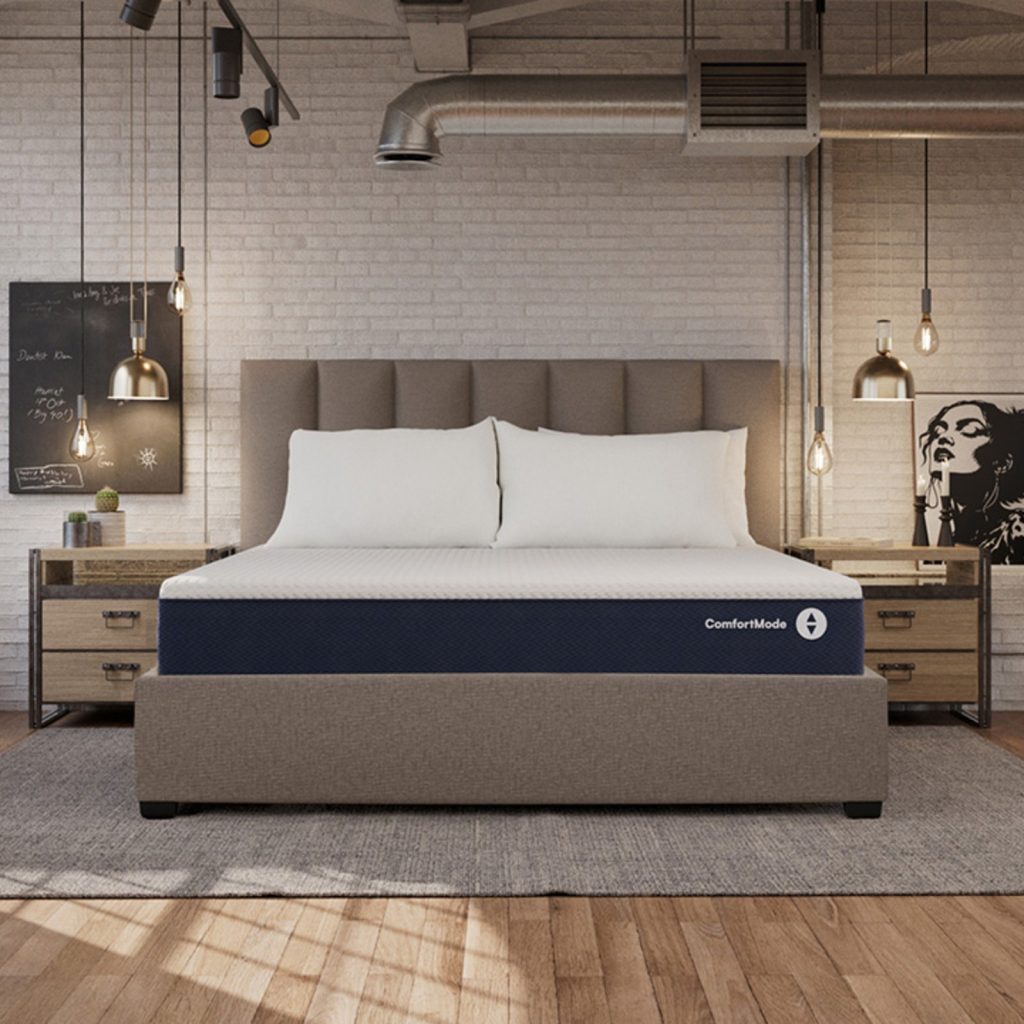 Sleep Number ComfortMode mattress on an upholstered bed in an industrial-style bedroom