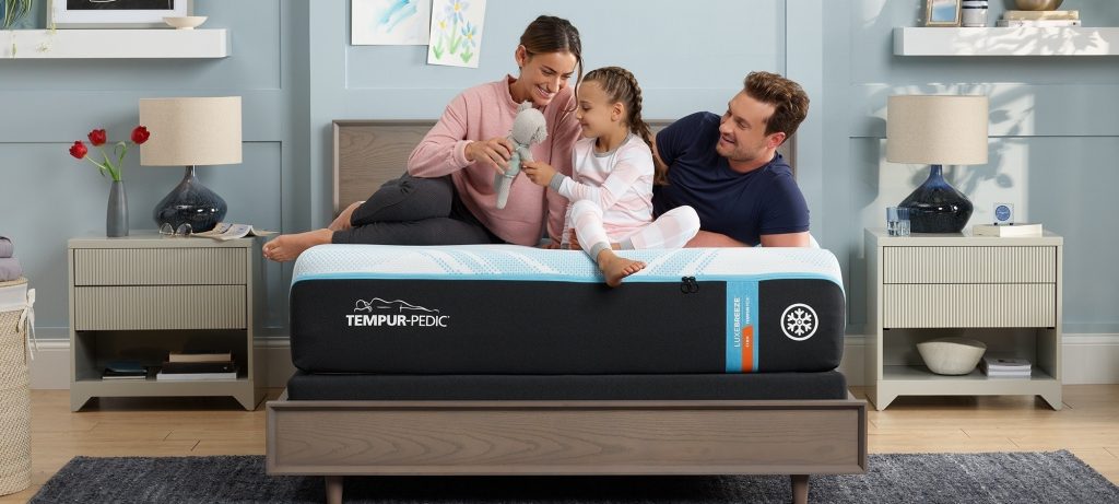 Parents and child on a TEMPUR-LuxeBreeze in a blue bedroom